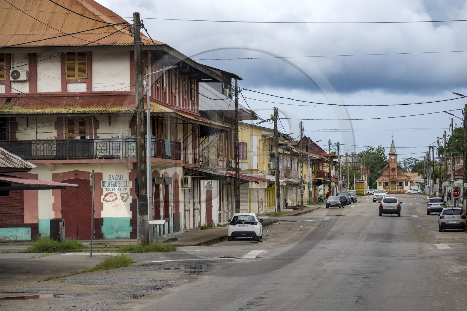 France, Guyane, Saint-Laurent-du-Maroni, maisons coloniales bordant l'avenue Felix Eboué dans la vieille ville et l'église de saint laurent du maroni en arrière plan