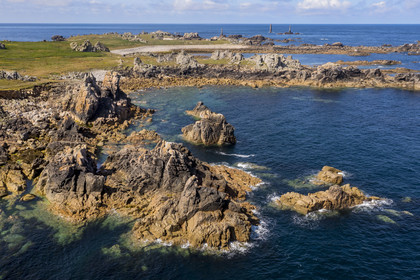 France, Finistère (29), Mer d'Iroise, Ile d'Ouessant, rochers façonnés par les tempêtes au pied du phare du Créac’h, le phare de Nividic sur la Pointe de Pern en arrière plan (vue aérienne)