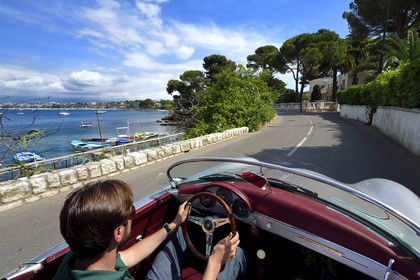 France, Alpes-Maritimes, Antibes, Cap d'Antibes, along the Gulf Juan on the Boulevard Maréchal Juin aboard a collection convertible Porsche Speedster 356