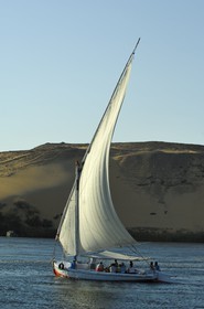Egypt, Upper Egypt, Nile Valley, Aswan, felucca on the Nil and sand dunes of the western bank