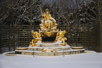 France, Yvelines, snow covered park of the Chateau de Versailles, listed as World Heritage by UNESCO, statue of the Triumphal Arch Grove