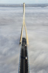 France, entre Calvados (14) et Seine-Maritime (76), le Pont de Normandie qui émerge des brumes matinales de l'automne et enjambe la Seine, vue depuis le sommet du pylone sud