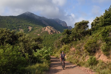 France, Var, Agay area next to Saint-Raphael, Massif de l'Esterel (Esterel Massif), Massif of Cap Roux, cyclist and mountain of Sainte-Baume in the background