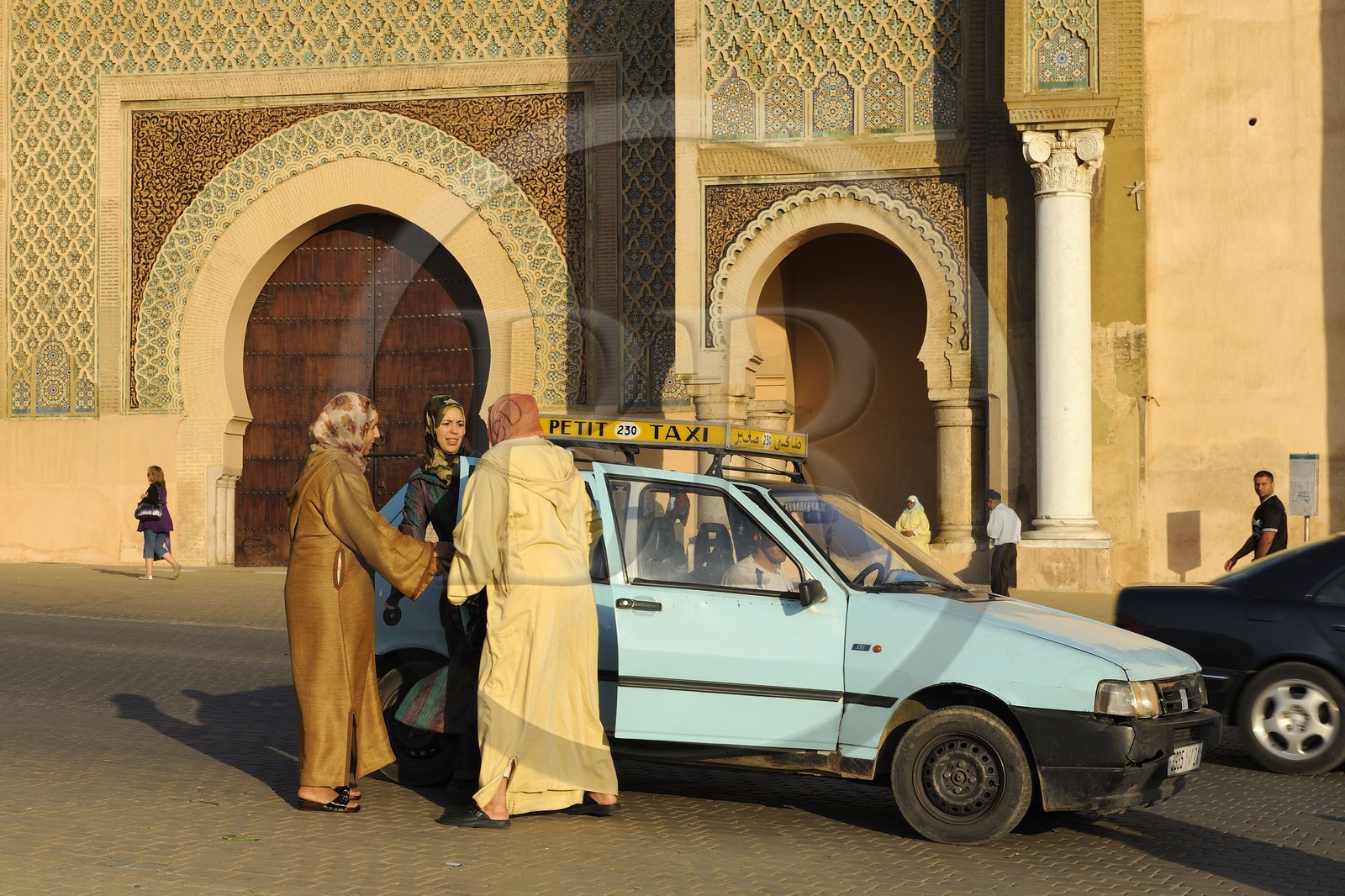 Maroc, Meknès, ville impériale, médina classée Patrimoine Mondial de l' UNESCO, taxi déposant ses clients devant la porte Bab el Mansour entre la cité impériale et la médina sur la place el Hédime ou Lahdim