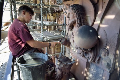 France, Bas Rhin, Strasbourg, old town listed as World Heritage by UNESCO, Notre Dame Cathedral, Judgment Day Portal Restoration Site, Christ Redeemer above King Solomon, cleaning the sculture with a toothbrush by a stonemason apprentice