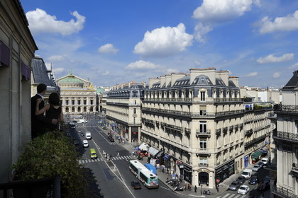 France, Paris, avenue de l'Opera, lovers on the balcony of their suite at hotel Edouard 7 with Opera Garnier (built 1875) in the background