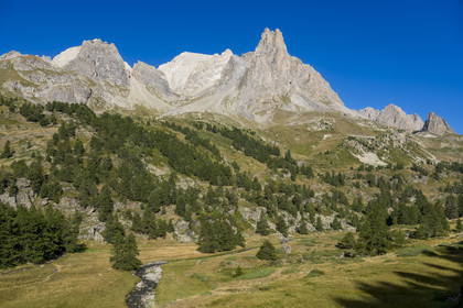 France, Hautes Alpes (05), le Briançonnais, Névache, randonneurs dans la vallée de la Clarée, le massif des Cerces et les pointes de la Main de Crépin (2942m) en arrière-plan