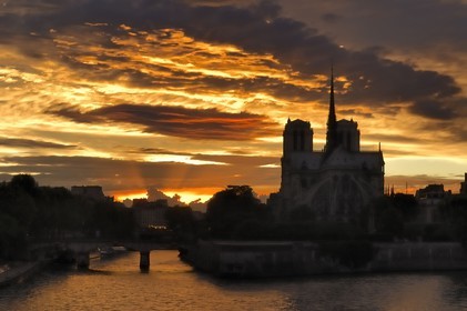 France, Paris (75), les rives de la Seine classées Patrimoine Mondial de l'UNESCO, un bateau-mouche devant la cathédrale Notre-Dame au soleil couchant