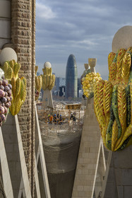 Espagne, Catalogne, Barcelone, quartier de l'Eixample, basilique de la Sagrada Familia de l'architecte du modernisme catalan Antoni Gaudi classée Patrimoine Mondial de l'UNESCO, sommets surmontés de mosaïques en forme de fruits entourant le chantier sur le toit de la nef à l'arrière de la future facade de la Gloire, la Torre Agbar de l'architecte Jean Nouvel en arrière plan