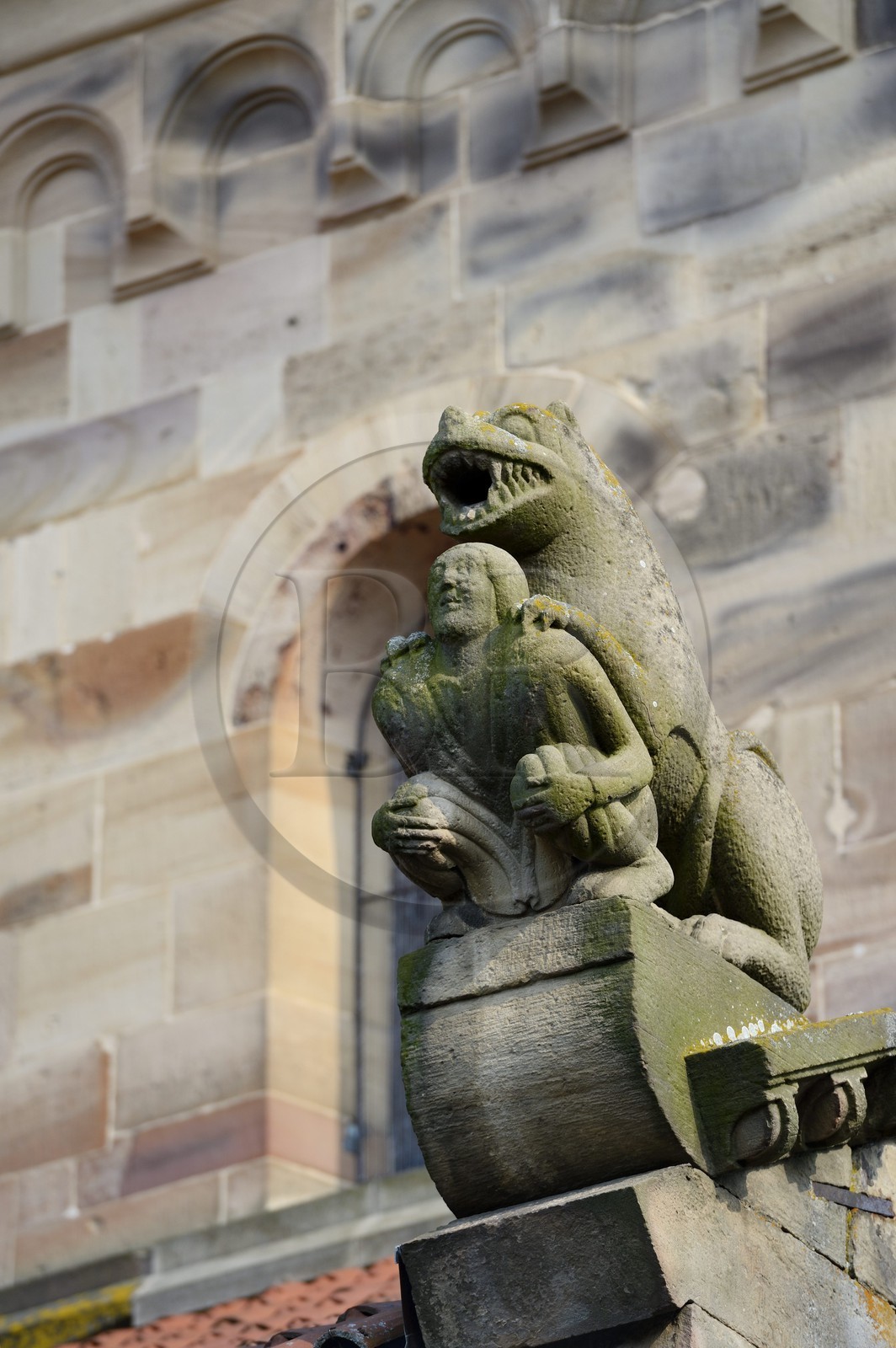 France, Bas Rhin, Rosheim village, St-Pierre and St-Paul roman Church, the lustful sculpture acroterion symbolizes sin, a lavishly dressed man appears crushed by a threatening lion