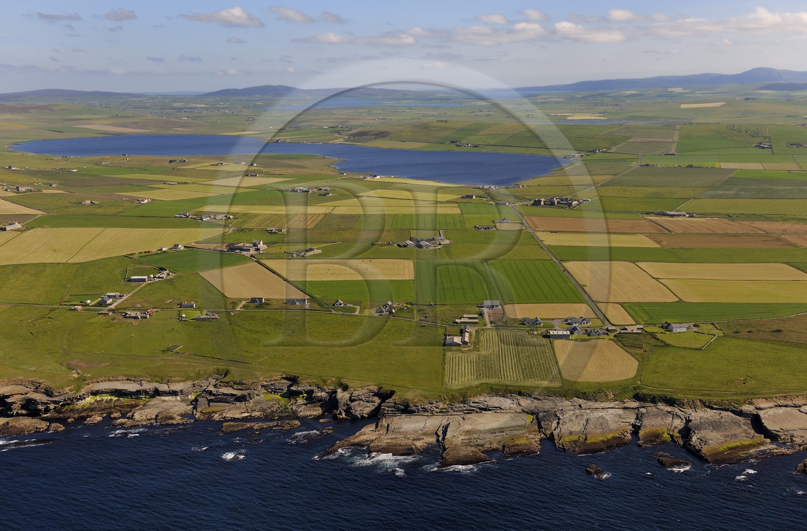 Royaume-Uni, Ecosse, Iles Orcades, Ile de Mainland, champs et fermes éparses en bordure de mer à Birsay, le Loch of Boardhouse en arrière plan (vue aérienne)