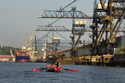 Spain, Basque Country, Biscay Province, Sestao, industrial port of Bilbao on the river Nervion centered on shipbuilding and also the iron and steel industry, ArcelorMittal plant on the right, Rowing training, very popular sport in the region