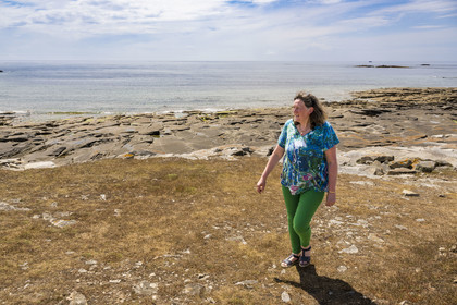 France, Finistère, Iroise Sea, Molene Island, Christine Demeure who manages the only grocery store on the island during her daily walk on the wild west coast, Flat Stones shore