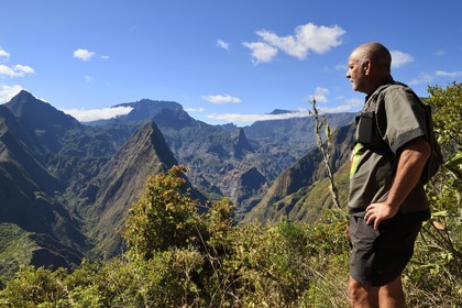 France, Reunion island (French overseas department), Reunion National Park listed as World heritage by UNESCO, La Possession, around village of Dos d'Ane, Roche Bouteille hike, the hiker François Gaulin on the Cap Noir trail and the Cirque de Mafate on the left