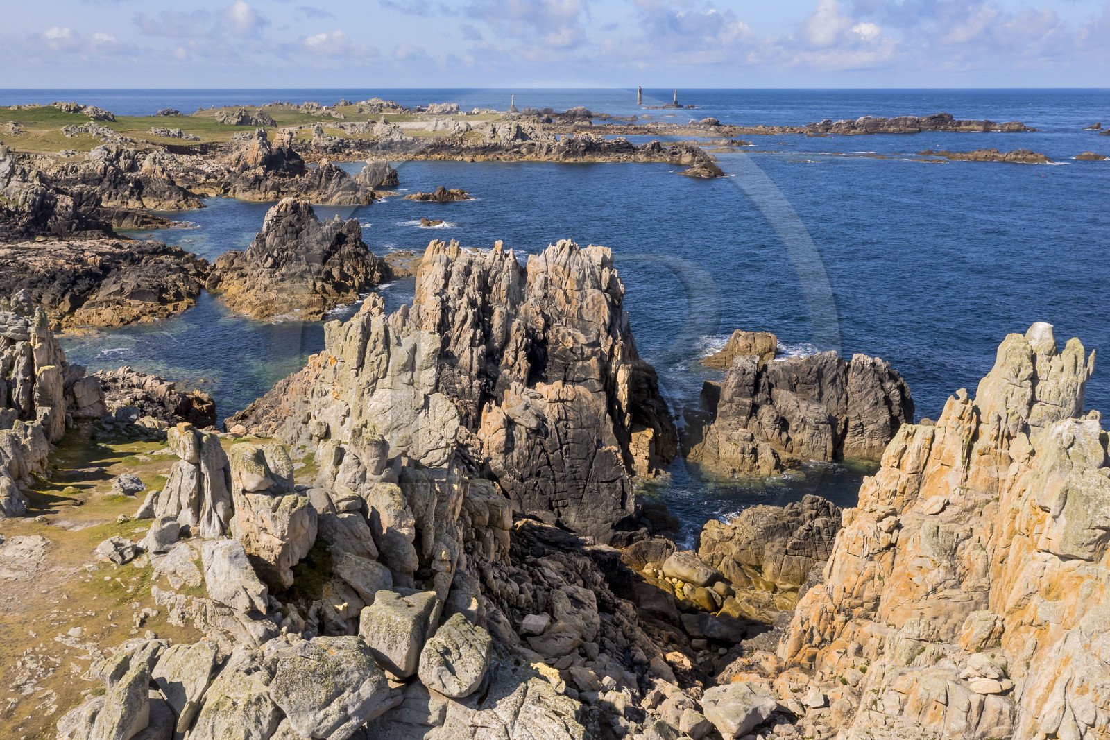 France, Finistère (29), Mer d'Iroise, Ile d'Ouessant, rochers façonnés par les tempêtes au pied du phare du Créac’h, le phare de Nividic sur la Pointe de Pern en arrière plan (vue aérienne)