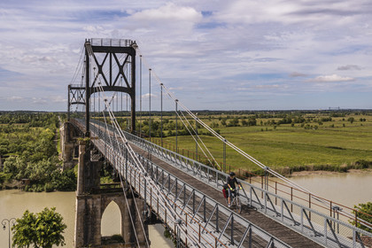 France, Charente-Maritime, Saintonge, Tonnay Charente, cyclist traveling along the Flow Vélo cycle route crossing the suspension bridge built in 1842 over the Charente river (aerial view)