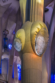 Spain, Catalonia, Barcelona, Eixample district, Sagrada Familia basilica by Catalan modernist architect Antoni Gaudi, listed as a UNESCO World Heritage Site, above the node, the columns of the central vessel (nave) are subdivided into branches like a tree, illuminated by the warm projections of the stained glass windows on the Passion facade