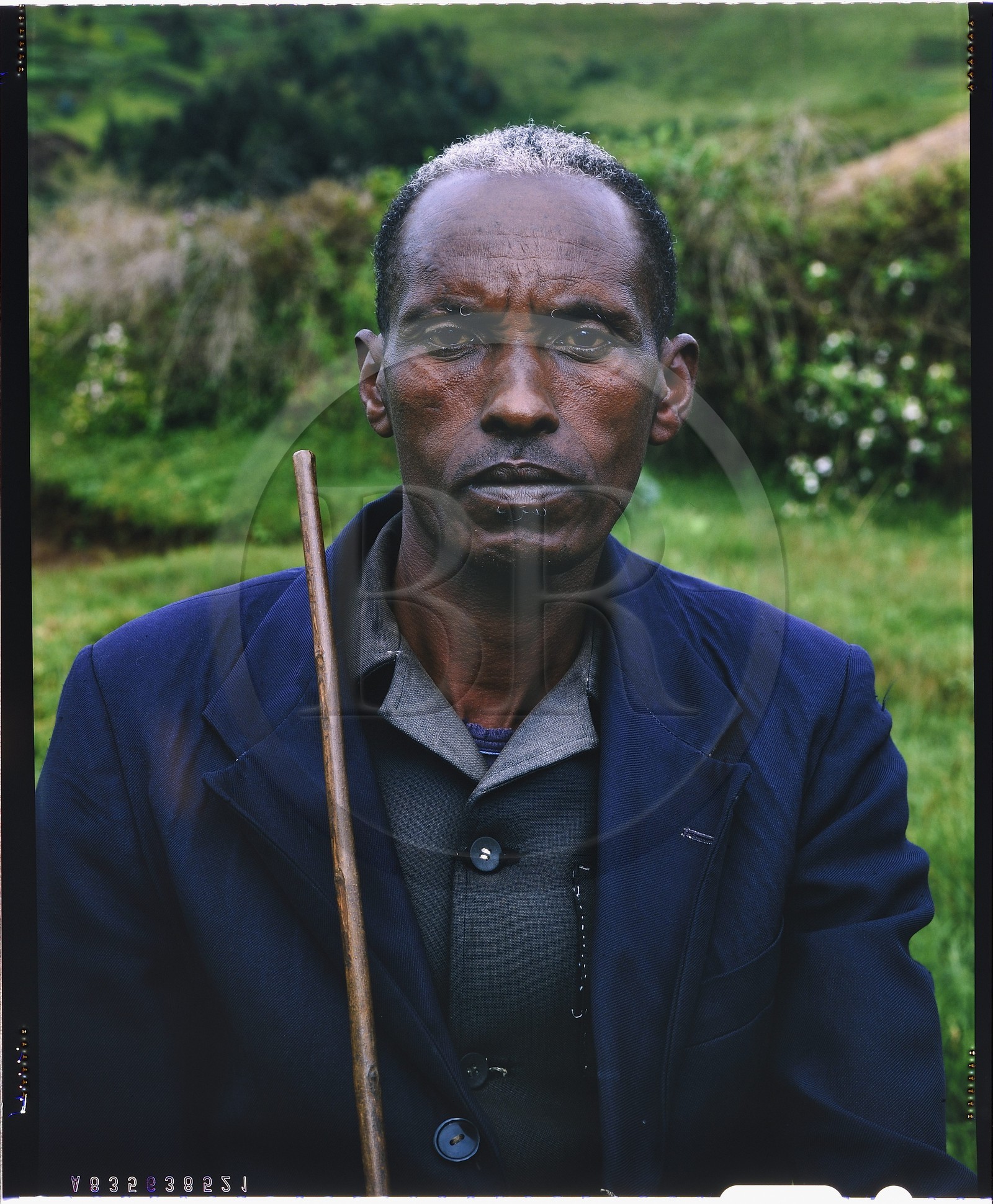 Burundi, province de Bujumbura, région d'Ijenda, chef de famille Tutsi, si les vêtements traditionnels en écorce de bois battu ont disparu depuis longtemps, la pose, fière et presque condescendante, reste identique, dans la région particulièrement traditionaliste d'Ijenda, les burundais ne sortent jamais sans avoir à la main un long bâton même si autrefois ils lui préféraient parfois la lance (reproduction plan-film inversible 4x5)