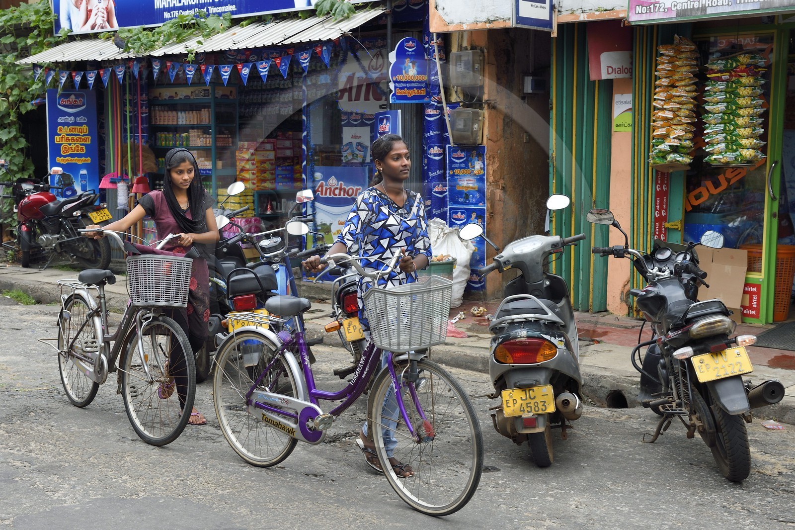 Sri Lanka, province de l'Est, Trincomalee, jeunes filles à bicyclettes devant des commerces de la rue principale