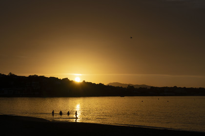France, Pyrenees Atlantiques, Basque Country, Saint Jean de Luz, walkers on the Grande Plage and the coast of Ciboure in the bay in the background