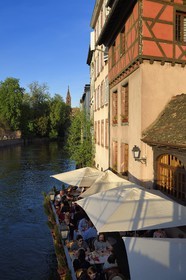 France, Bas-Rhin (67), Strasbourg, vieille ville classée au Patrimoine Mondial de l'UNESCO, quartier de la Petite France, terrasse de restaurant sur un bras de l'Ill, la cathédrale Notre Dame en arrière plan