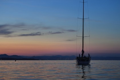 France, Var, Iles d'Hyeres, Parc National de Port Cros (National park of Port Cros), Porquerolles island, boat at anchor at dusk, the Giens peninsula in the background