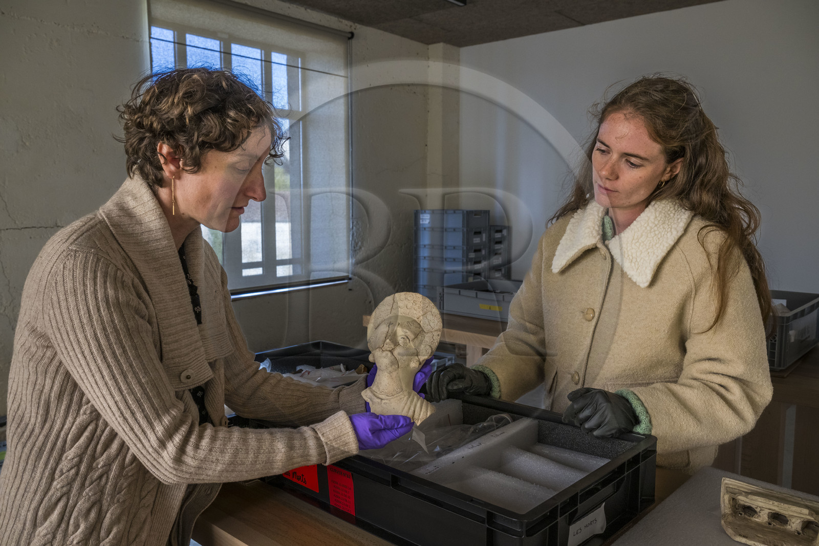 France, Saône-et-Loire (71), Autun, réserves du musée Rolin, la directrice des musées  Agathe Mathiaut-Legros et du patrimoine et la conservatrice adjointe Axelle Goupy manipulant une figurine en terre cuite gallo-romaine d'une nécropole