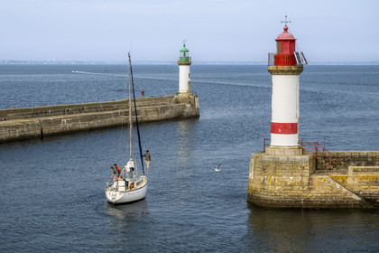 France, Morbihan, Groix Island, Port Tudy, sailboat between the two beacons at the entrance to the port