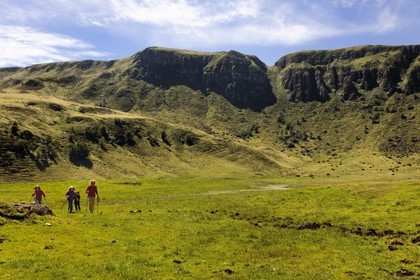France, Cantal, France, Cantal, monts du Cantal, Parc Naturel Régional des Volcans d'Auvergne (regional nature park of Auvergne volcanoes), Puy-Mary, family of hikers at the foot of the mountain of the Fours de Peyre Arse cut by the breach of Roland