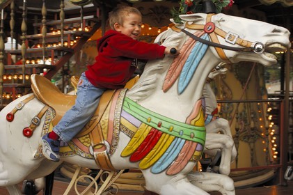 France, Paris, Parc de la Villette, child on a wooden horse in a old merry-go-round