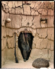Burkina Faso, Poni province, Lobi land, Loropéni, young Lobi coming out of his father's house with the attributes of the initiates: bow, quiver and hoe