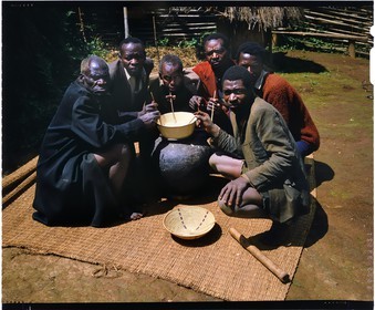 Burundi, Bujumbura Province, Ijenda area, men in front of a traditional hut drinking the sorghum beer (traditional beer), there is little Burundi life circumstances where they do not offer and consume the beer, in fact a low alcohol drink made from sorghum, banana or even honey (4x5 reversal film reproduction)