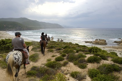 France, Haute Corse, Nebbio, Agriates Desert, Peraiola Cove, riders on the North-East of Ostriconi beach on the Punta di l’Acciolu (Acciola)
