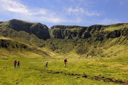 France, Cantal, France, Cantal, monts du Cantal, Parc Naturel Régional des Volcans d'Auvergne (regional nature park of Auvergne volcanoes), Puy-Mary, family of hikers at the foot of the mountain of the Fours de Peyre Arse cut by the breach of Roland