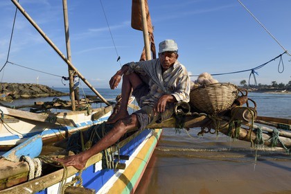 Sri Lanka, Western Province, Negombo, fisherman on his traditional catamaran after the morning fishing, on the Porathota beach