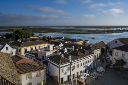 Portugal, Algarve, Faro, old town, cafe terraces on Largo da Sé square and the lagoon of the Ria Formosa Natural Park in the background