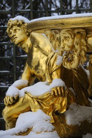 France, Yvelines, snow covered park of the Chateau de Versailles, listed as World Heritage by UNESCO, detail of a statue of the Triumphal Arch Grove