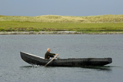Republic of Ireland, County Galway, Aran Islands, Inishmore, Killeany Bay, curragh (traditional wooden boat with tarpaulin)
