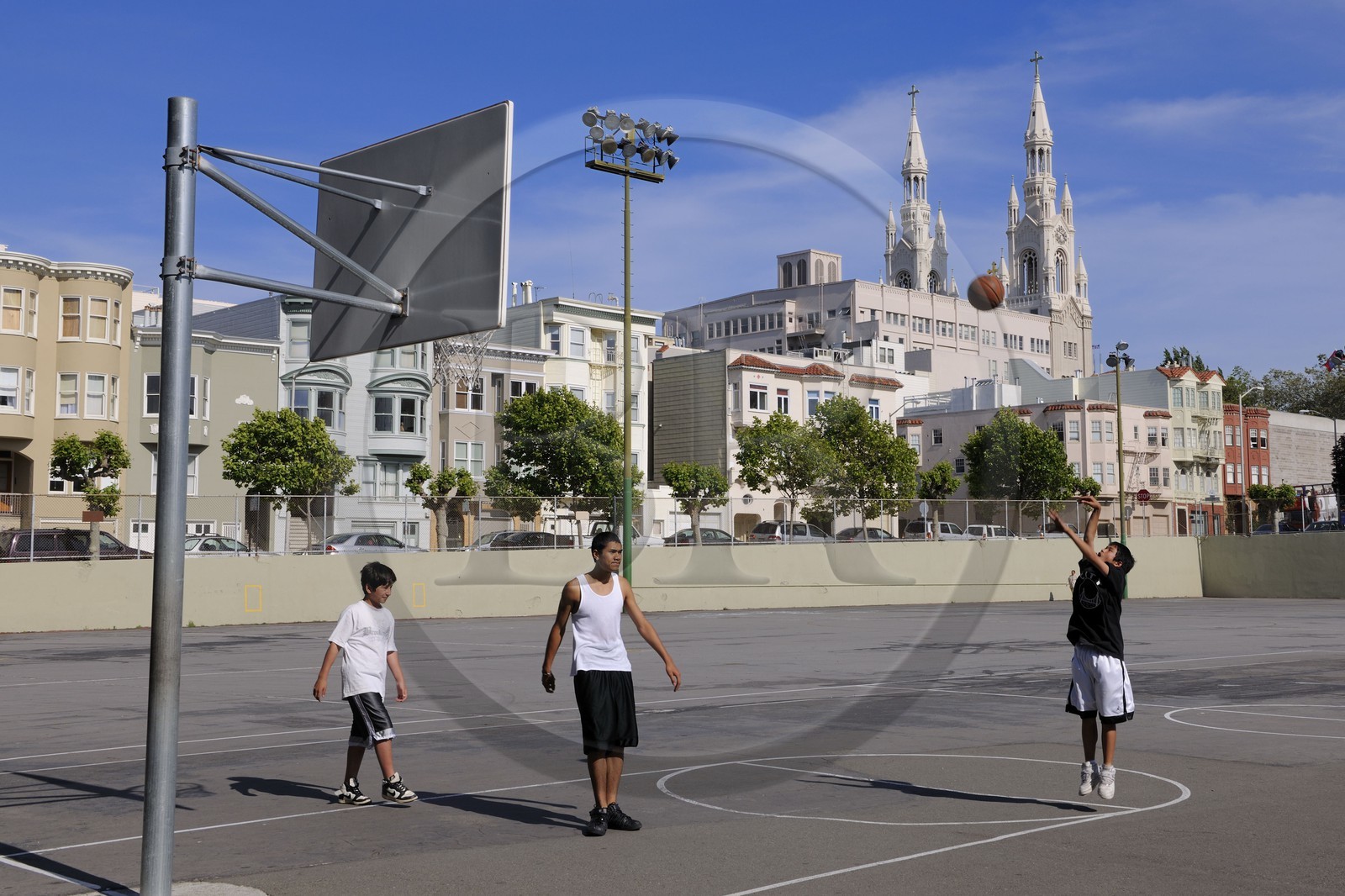 Etats-Unis, Californie, San Francisco, terrain de basket à l'angle de Powell street et Lombard street dans le quartier de North Beach et les flèches de l'église Sts Peter and Paul church