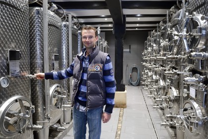 France, Bas Rhin, the Alsace Wine Route, Traenheim, Wine estate Frederic Moshel, the producer Guillaume Moshel with his stainless steel tanks