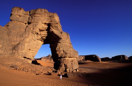 Libya, region of the desert, the Fezzan (Sahara), Tadrart Akacus, Tuareg under the arch (in sandstone) of Afazedja
