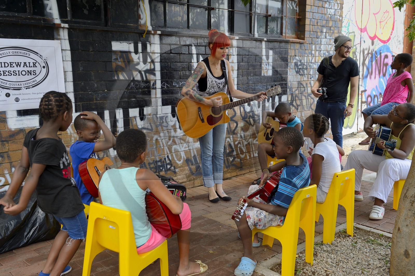Afrique du Sud, province de Gauteng, Johannesburg, CBD (Central Business District), quartier de Maboneng, Sidewalk Sessions dans Fox street, Kelly Grevler donne des cours de guitare gratuits pour de jeunes enfants dans la rue