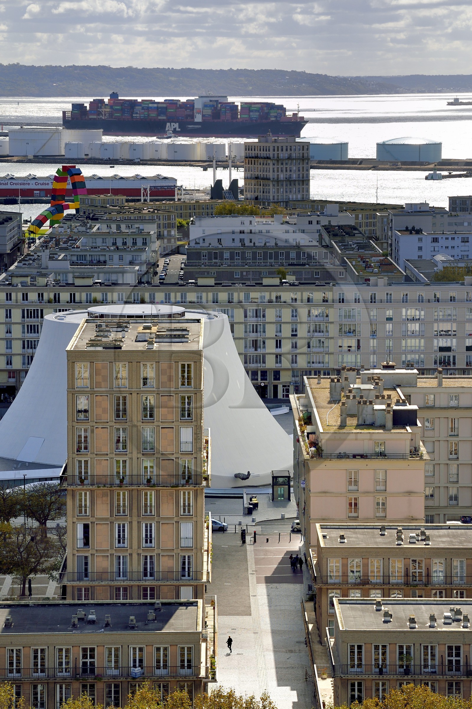 France, Seine-Maritime (76), Le Havre, Centre-ville reconstruit du Havre par Auguste Perret classé Patrimoine Mondial de l'UNESCO, immeubles Perret autour du Volcan réalisé par Oscar Niemeyer, un porte-conteneurs en arrière plan sort du port de commerce