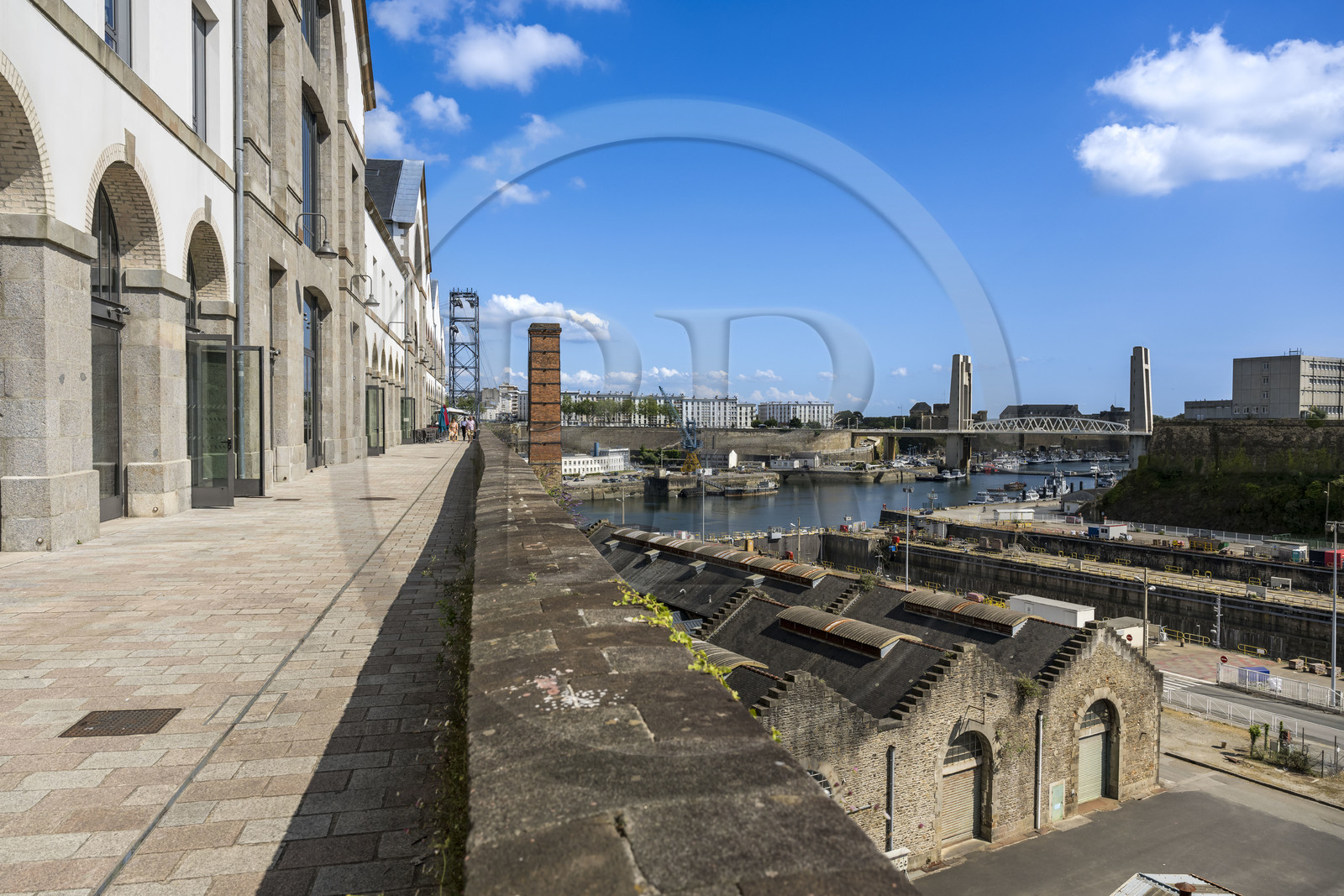 France, Finistère (29), Brest, l'éco-quartier des Capucins, les Ateliers, les anciennes halles de fonderies, d'ajustage et de montage du plateau des Capucin au dessus des bassins de Pontaniou dans l’Arsenal, le pont de Recouvrance en arrière plan