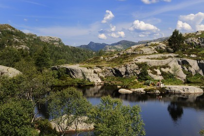 Norway, Rogaland County, around Lysefjord, campers on the edges of a small lake on the hiking trail leading to Preikestolen Rock