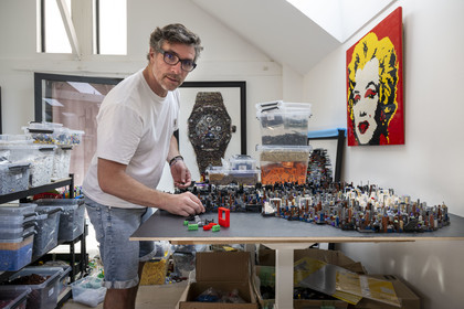 France, Cote d'Or, Dijon, Artist Aymeric Gillet, aka M'Brick, in his studio filled with crates of multicolored Lego used to create giant pixelated paintings inspired by pop culture