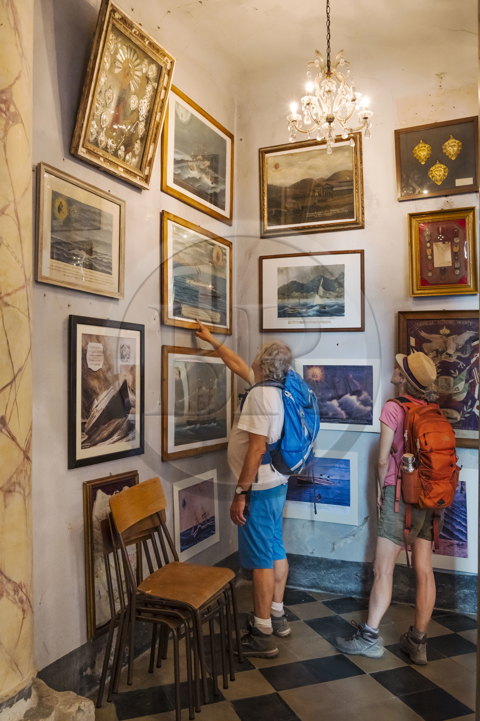 Italie, Ligurie, Cinque Terre, parc national des Cinque Terre classé Patrimoine Mondial de l'UNESCO, randonneurs observant les Ex-Voto dans l'église du sanctuaire de Nostra Signora di Reggio sur les hauteurs du village de Vernazza