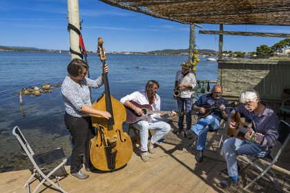 France, Hérault (34), Sète,  Pointe du Barrou sur les rives de l'étang de Thau, le groupe de musique Au Bois de mon cœur qui réinterprète les chansons de Georges Brassens, il est mené par le pêcheur sétois Jean-Louis Lambert au chant et à la guitare, Georges Cabaret à la guitare solo, Guy Blanc dit Guet au saxo alto, Denis Benito à la mandoline bluegrass et Tatiana à la contrebasse