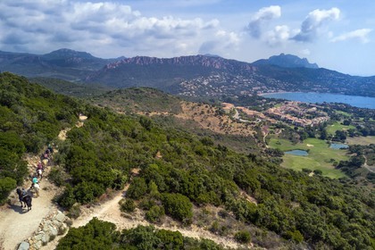 France, Var, Agay area next to Saint-Raphael, riders trekking in the Massif de l'Esterel (Esterel Massif), the rastel d'Agay and the peak of Cap Roux in the background (aerial view)