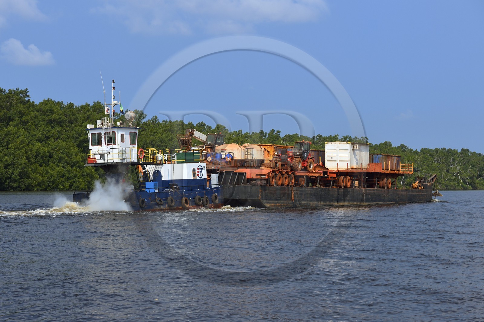 Gabon, Ogooue-Maritime Province, Port-Gentil region, boat pushing a barge of earthmoving machines on a river opening onto the bay of Cape Lopez, the lack of roads is compensated by the use of rivers